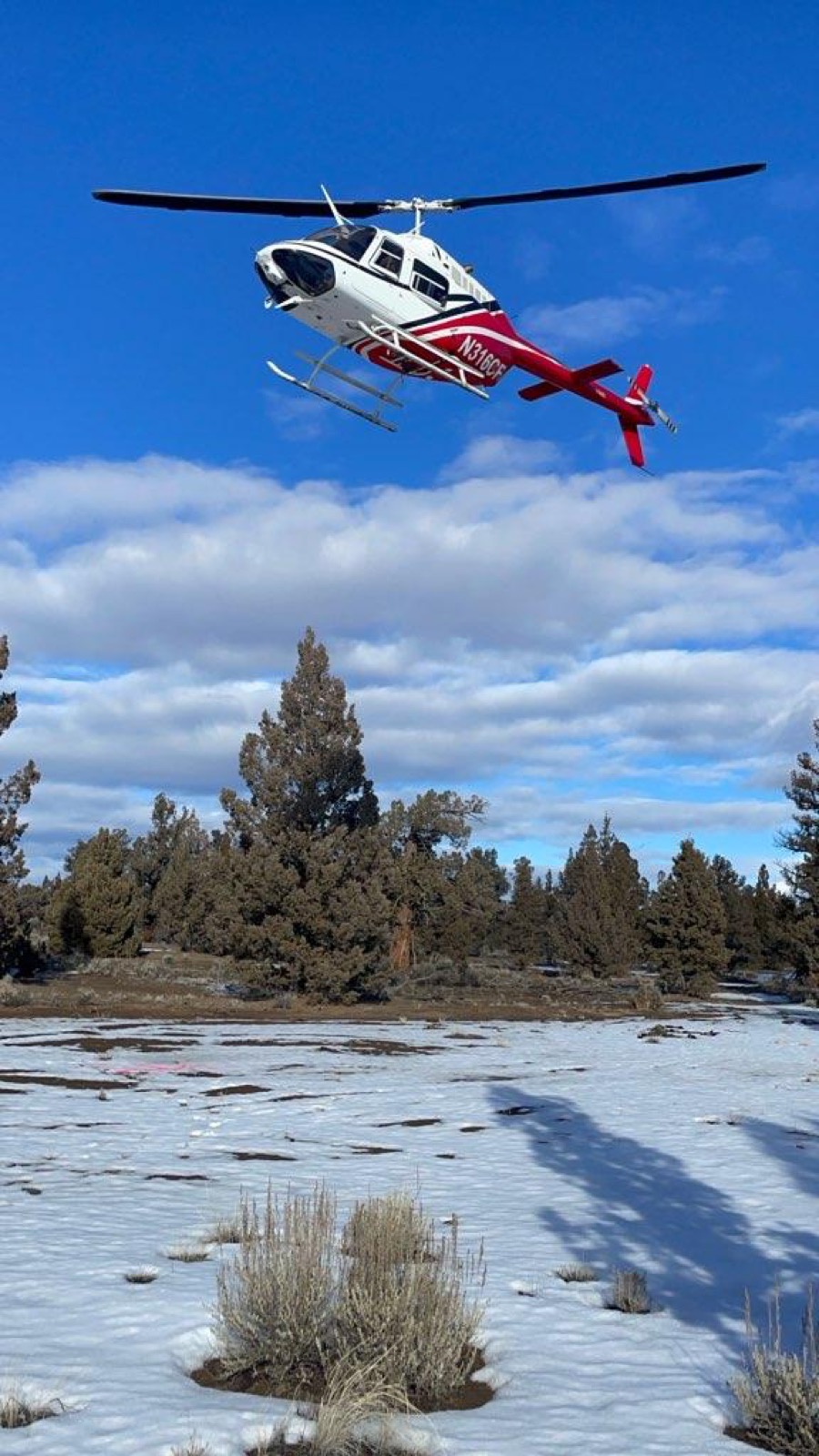 Bell helicopter in flight over snowy terrain